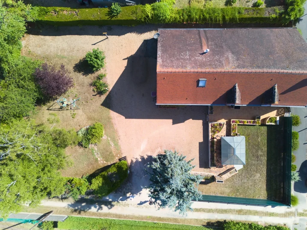 Vue aérienne du gîte D'Annie avec balançoire, terrasse, barbecue, salon de jardin