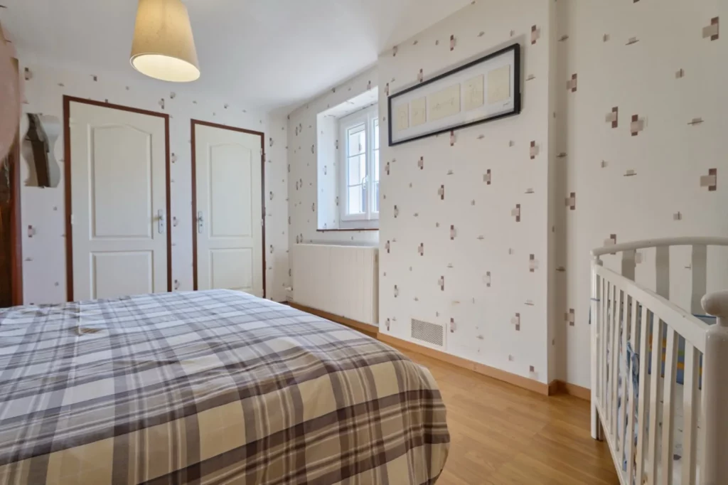 Vue d'ensemble de la chambre parentale avec lit bébé