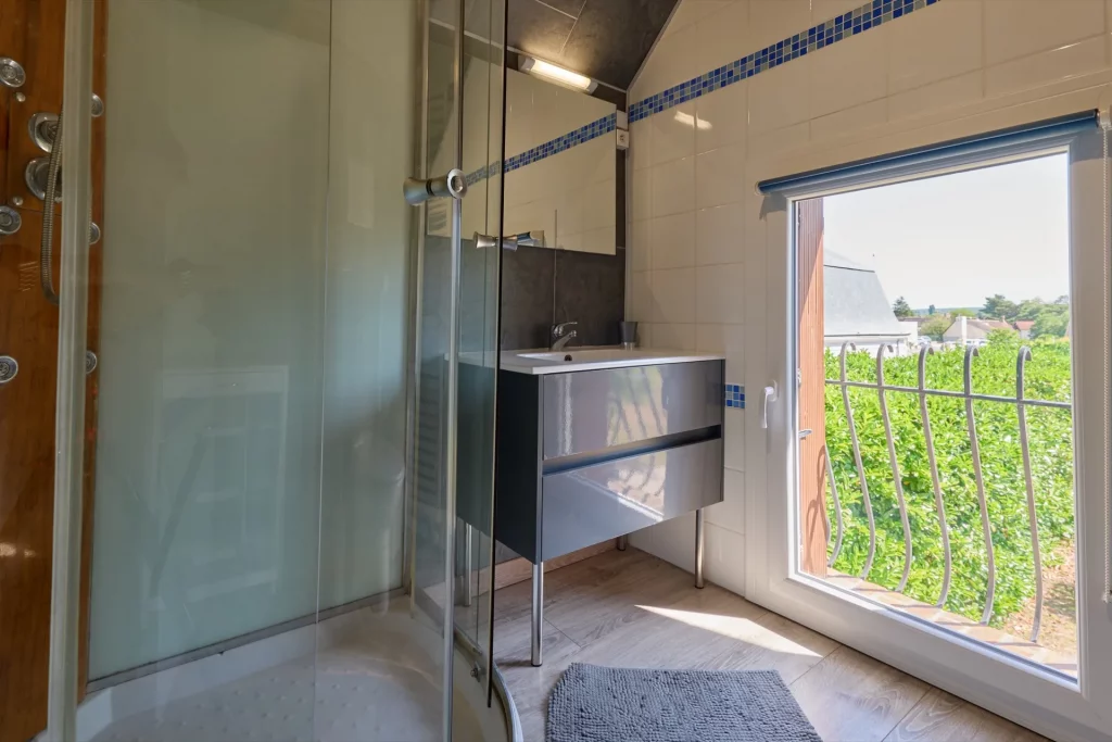 Plan sur la vasque et la douche de la salle de bain à l'étage