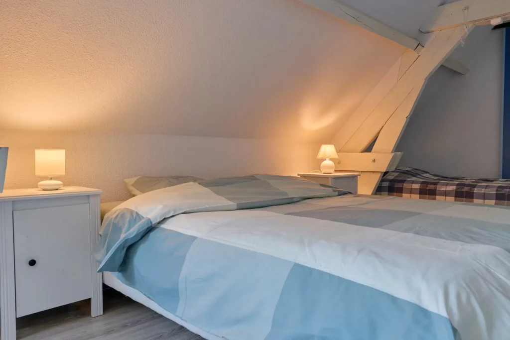 Gros plan sur un lit double de la chambre à l'étage